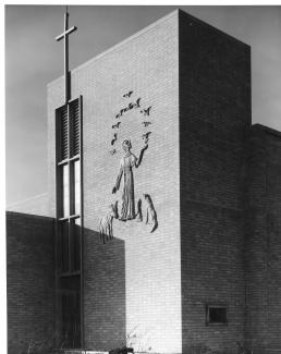 St. Aidan carrying a torch on the façade of St. Aidan of Lindisfarne, East Acton