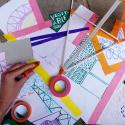 Colourful paper, ribbons and tape with children's hands